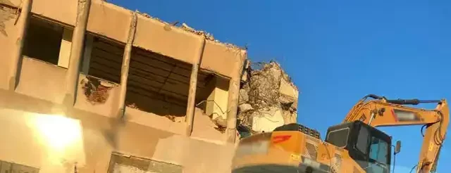 abbattimento edificio abusivo con ruspa